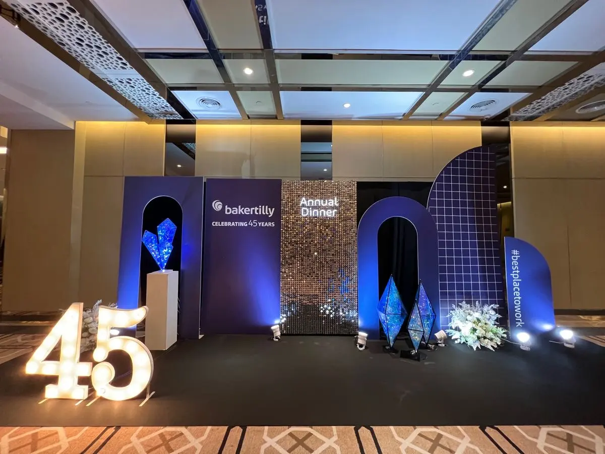Anniversary dinner photo wall with sculptural lighting and branded details