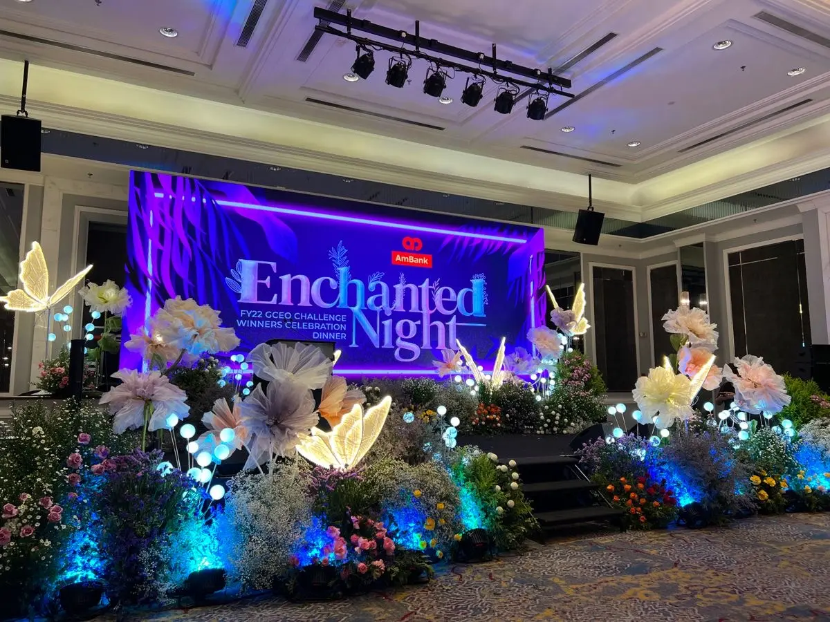 Enchanted Night corporate dinner stage with illuminated floral styling